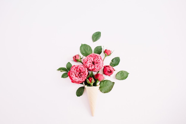 Cône De Gaufre Avec Bouquet De Roses Rouges Sur Fond Rose Pastel Pâle. Mise à Plat