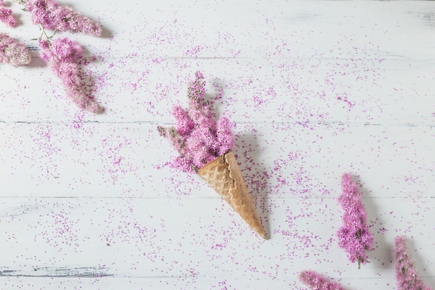 Cône de gaufre avec des fleurs roses sur blanc