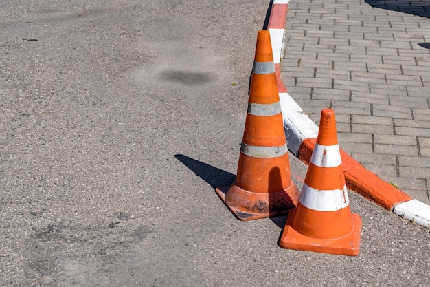 Cône orange blanc de danger de circulation sur la réparation de route d'asphalte