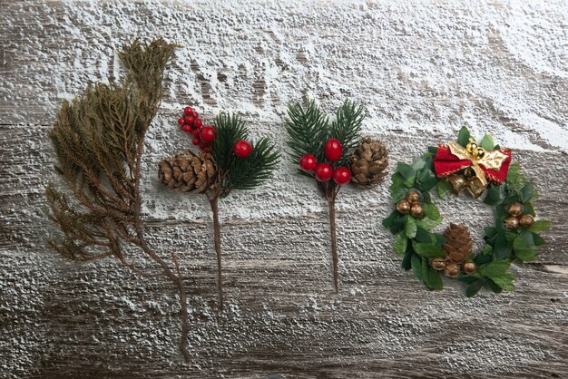 Cône de pin avec une cloche sur un fond en bois enneigé. décoration de Noël