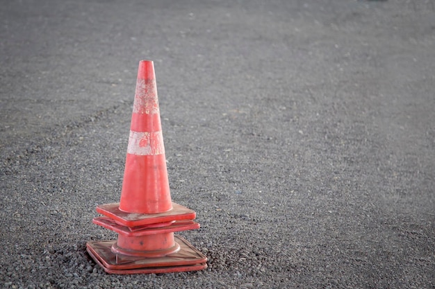 Un cône de signalisation rouge se trouve au milieu d'une route