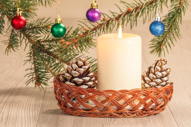 Cônes de bougie allumés et branches de sapin naturel avec boules de Noël