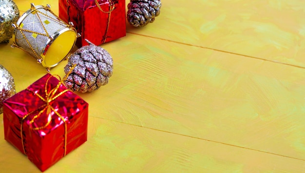 Photo des cônes brillants, des cadeaux et d'autres décorations de noël sur une table en bois