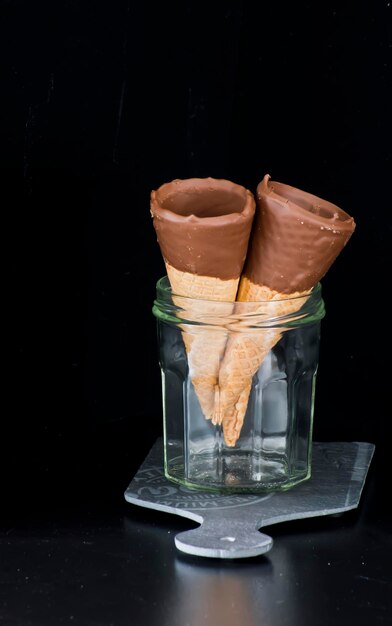 Cônes de chocolat dans un bocal en verre. Fond sombre