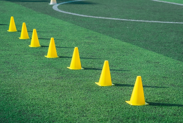 Cônes d'entraînement sport jaune sur terrain de football