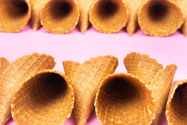 Photo cônes de gaufres vides pour la crème glacée sur fond rose.
