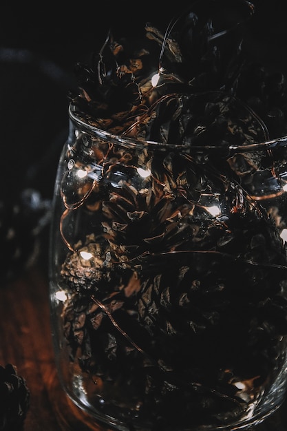 Cônes avec guirlande dans un vase en verre noël noël vacances nouvel an hiver lumière décorations festives