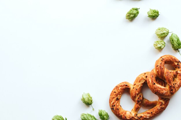 cônes de houblon et bretzels sur blanc