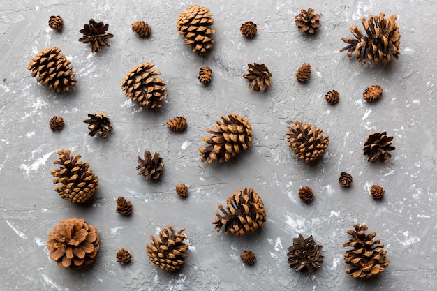 Cônes de pin sur table de couleur fond naturel de vacances avec des pommes de pin regroupées Concept d'hiver à plat