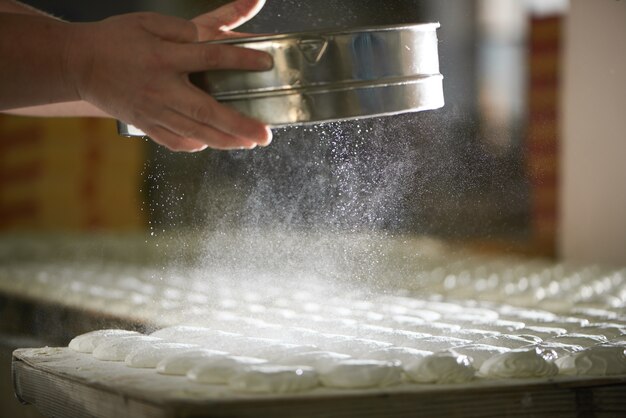 Photo confectioner la poussière de farine sur la guimauve blanche