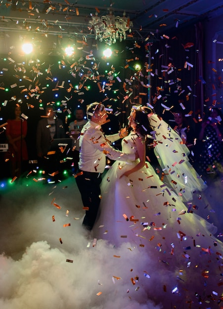 Confetti tomber sur un couple de mariage tourbillonnant dans la fumée