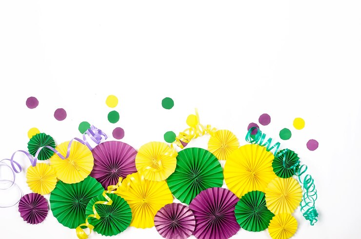 Confettis en papier coloré, masque de carnaval et serpentine colorée sur fond jaune