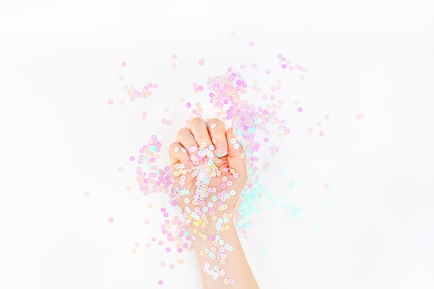 Des confettis pastel nacrés étincellent de main de femme