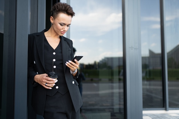 Confiant businesswoman texting email lettre sur téléphone portable à l'aide d'Internet