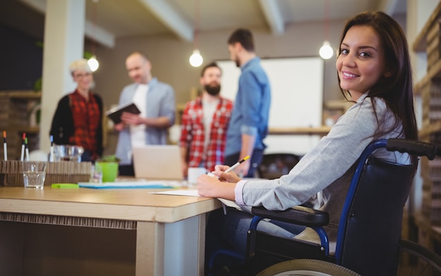 Confiant femme d'affaires handicapée écrit au bureau