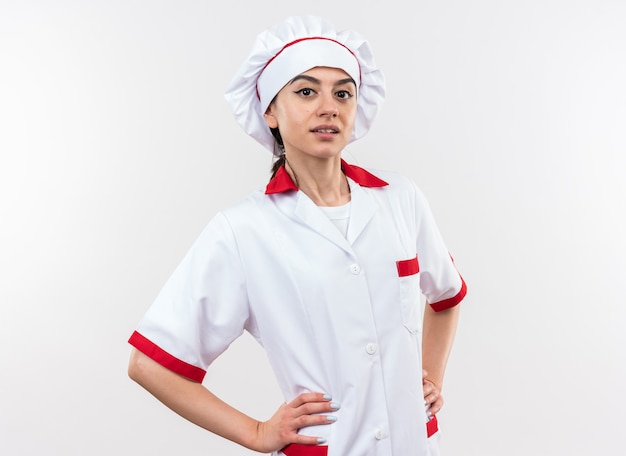 Confiant jeune belle fille en uniforme de chef mettant les mains sur la hanche