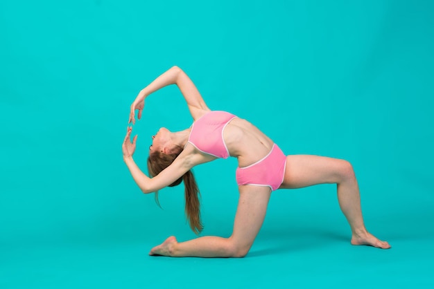 Confiant superbe belle jeune femme en sous-vêtements montrant un corps en forme sur fond bleu et jaune