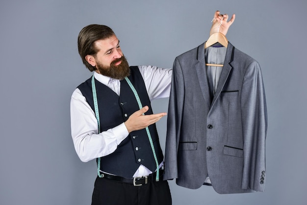 Confiant tailleur conception veste masculine beau sartor avec ruban à mesurer beauté masculine et mode homme barbu confection de vêtements formel et bureau garde-robe homme d'affaires