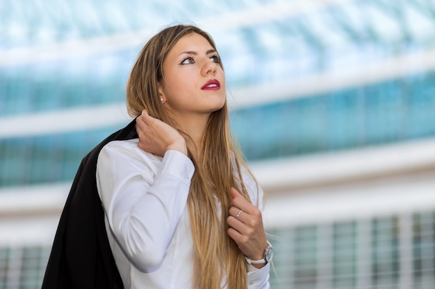 Confiante jeune femme gestionnaire en plein air dans un cadre urbain moderne