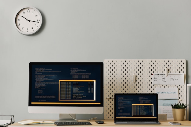 Configuration du lieu de travail de bureau avec code informatique sur deux écrans