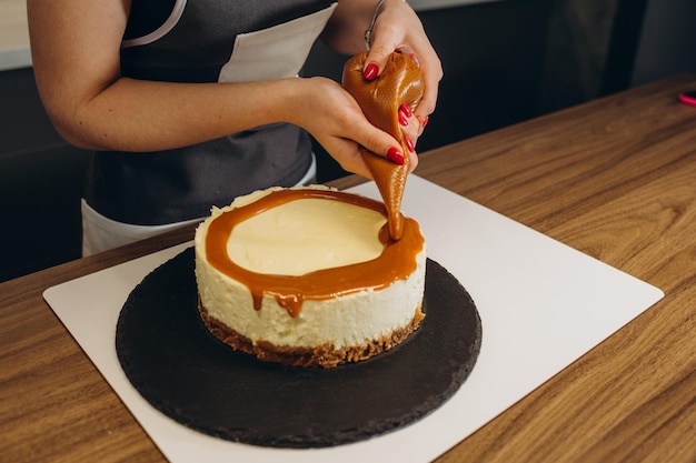 Photo confiseur décorant un gâteau au chocolat dans une pâtisserie