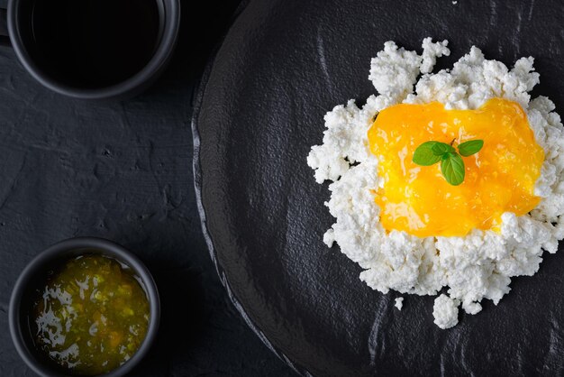 Confiture de citron avec du fromage cottage en gros plan bol noir