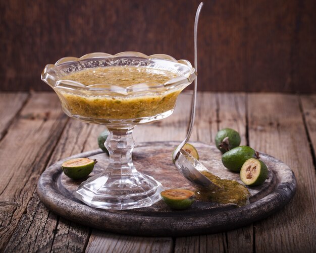 Confiture de feijoa dans un vase en verre sur une planche de bois