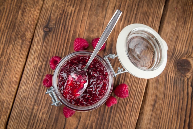 Confiture de framboises fraîches sur un fond rustique