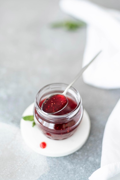 Confiture de framboises maison dans un bocal en verre avec cuillère