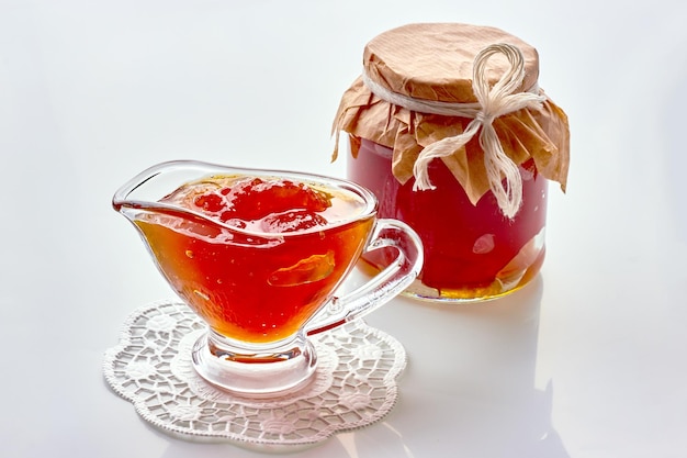 Confiture de fruits sucrée maison dans une saucière en verre et un bocal