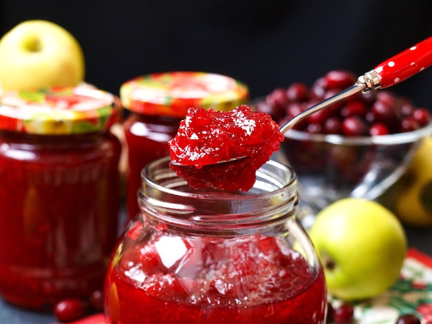 Confiture maison de cornouillers et pommes en bocaux avec des pommes autour