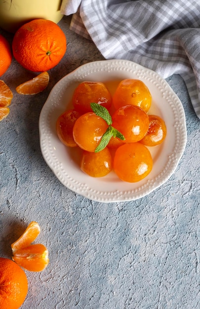 Confiture de mandarine dans un bocal en verre avec des fruits autour