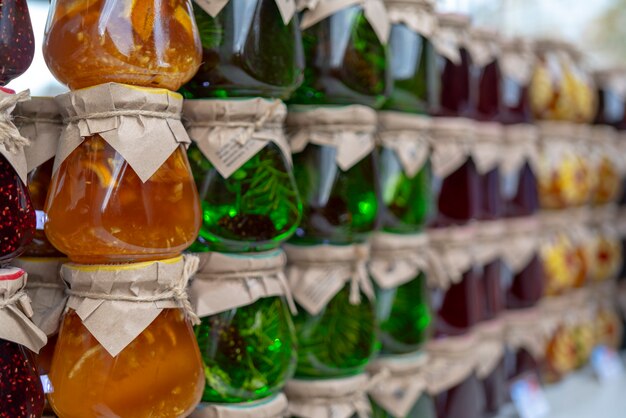 Confiture multicolore de fruits et baies dans des bocaux en verre.