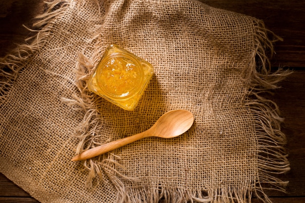 Confiture d&#39;orange dans une bouteille carrée sur le sac