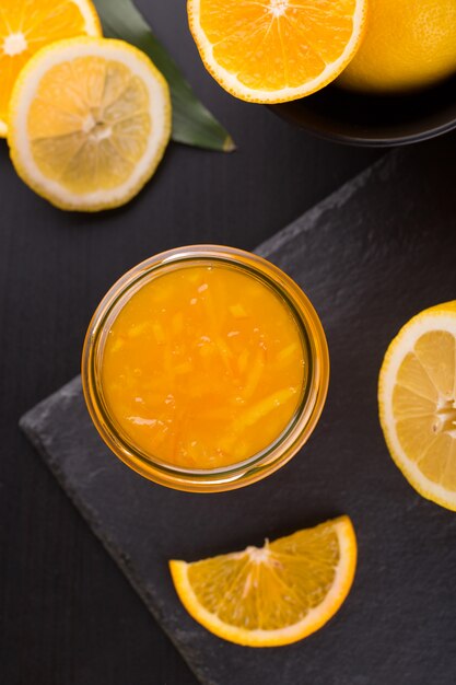 Photo confiture d'orange maison dans un pot sur une table en pierre noire