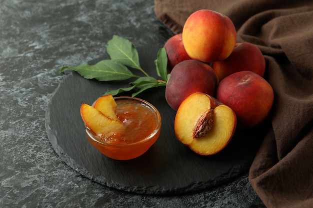 Confiture de pêches et ingrédients sur table smokey noire