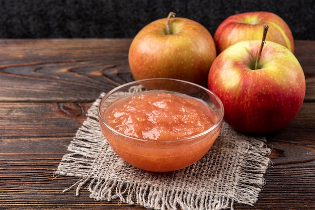 Confiture de pomme sur fond en bois foncé.