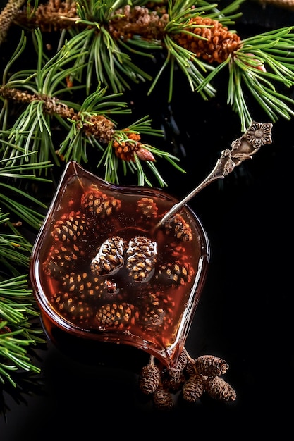 Confiture de pommes de pin dans une tasse en verre pommes de pin sucrées dans une cuillère photo d'aliments sains