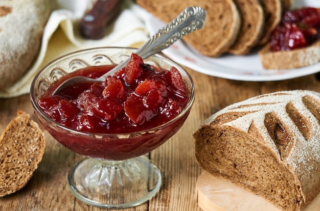 Confiture de prunes dans un bol en verre sur une table en bois