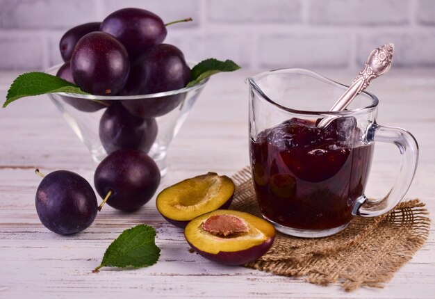 Confiture de prunes en saucière en verre. Fond blanc.