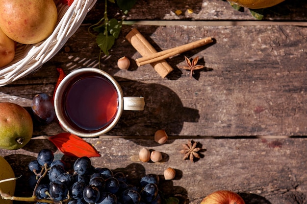 Confortable automne nature morte rustique tasse de thé fruits légumes noisettes et bâtons de cannelle automne confort esthétique concept de Thanksgiving Day avec place pour le texte