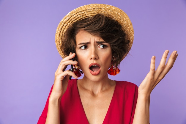 Confus Jolie femme brune en robe et chapeau de paille