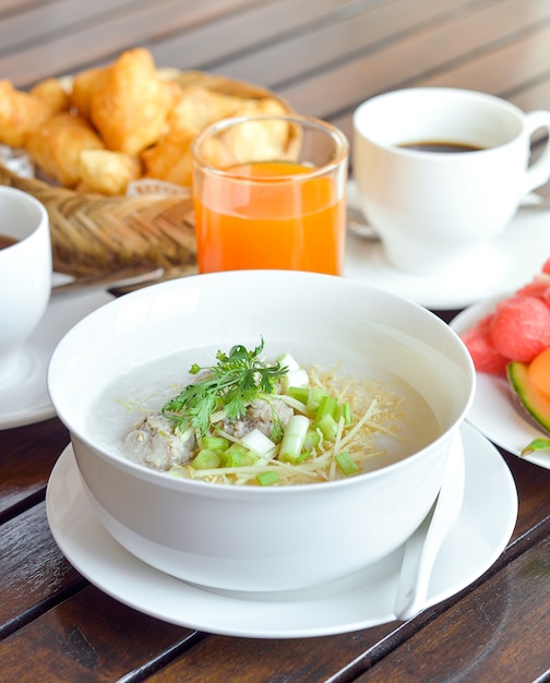 Congee avec du porc haché servi tranche de coriandre au gingembre et oeuf, petit-déjeuner asiatique