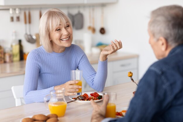 Conjoints seniors souriants profitant d'un repas sain ensemble