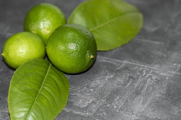 Conjunto de limones verdes fresques sobre fondo gris