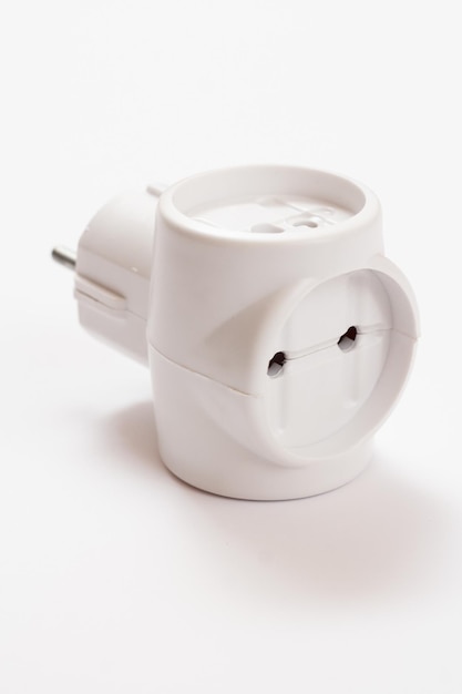 Connecteur en té électrique en plastique avec trois prises sur fond blanc.