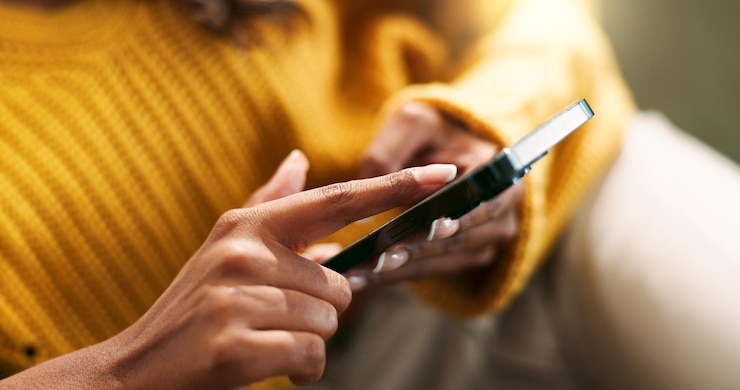Photo connexion des mains et smartphone à la maison pour la frappe de défilement et le message texte sur le canapé dans le salon réseau de personne féminine et application mobile pour créer un profil de chat et explorer sur le site de rencontres