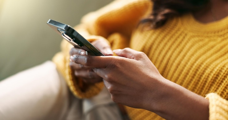 Photo connexion des mains et téléphone à la maison pour le défilement, la frappe et le message texte sur le canapé dans le salon réseau de personnes féminines et application mobile pour créer un profil, discuter et explorer sur le site de rencontres sur le canappé