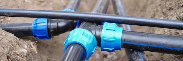 Connexion de tuyaux en plastique d'approvisionnement en eau sur l'égout du jardin au sol et le système d'irrigation