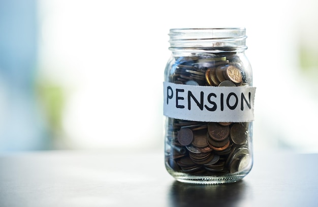 Économisez chaque centime et chaque dollar Photo d'un pot d'argent de pension sur une table à la maison